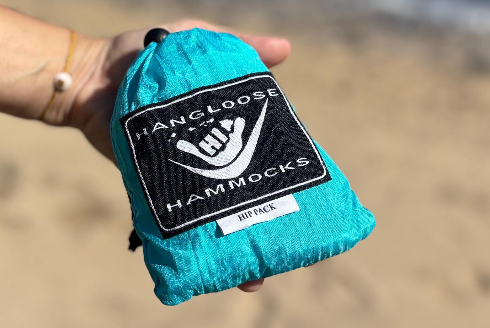 Hand holding a parachute hip back from Hangloose Hammocks